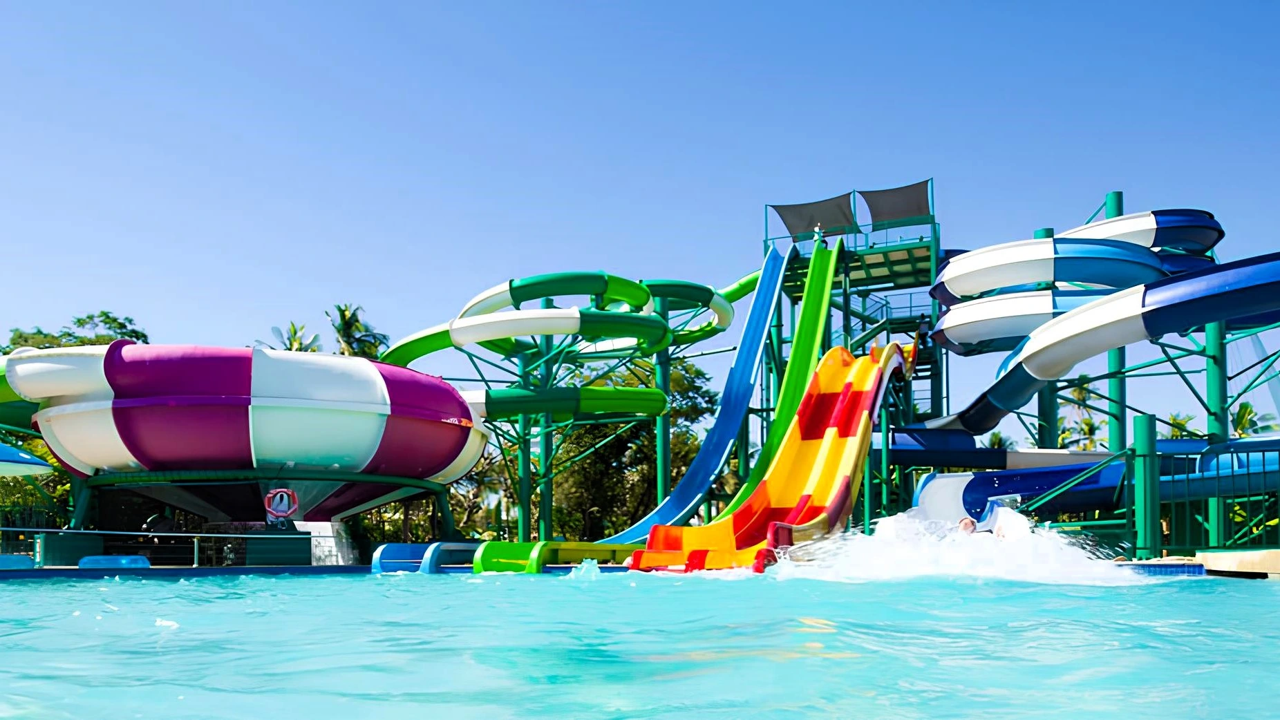 مدينة ألعاب مائية (أكوا بارك) تضم زحاليق مائية فيبر جلاس ملونة، تشمل زحليقة فيبر جلاس خضراء ملتوية ومنزلق مائي مموج بألوان متعددة، تصب جميعها في حمام سباحة صافٍ لتوفير أفضل تجهيزات ملاهي مائية.